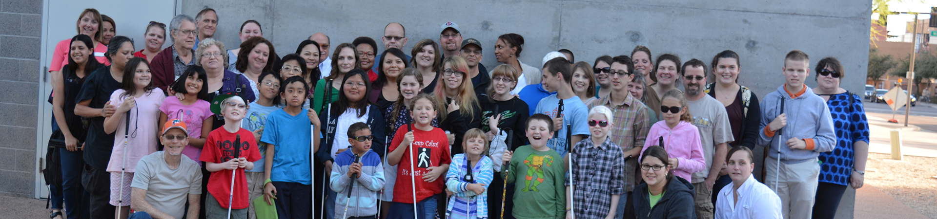 A large group of blind kids and mentors pose together for a photo.